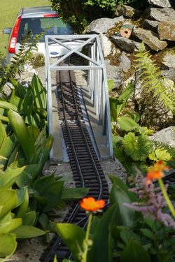 Bahnbrücke mit Blume im Vordergrund. Focus ist auf der Brücke.